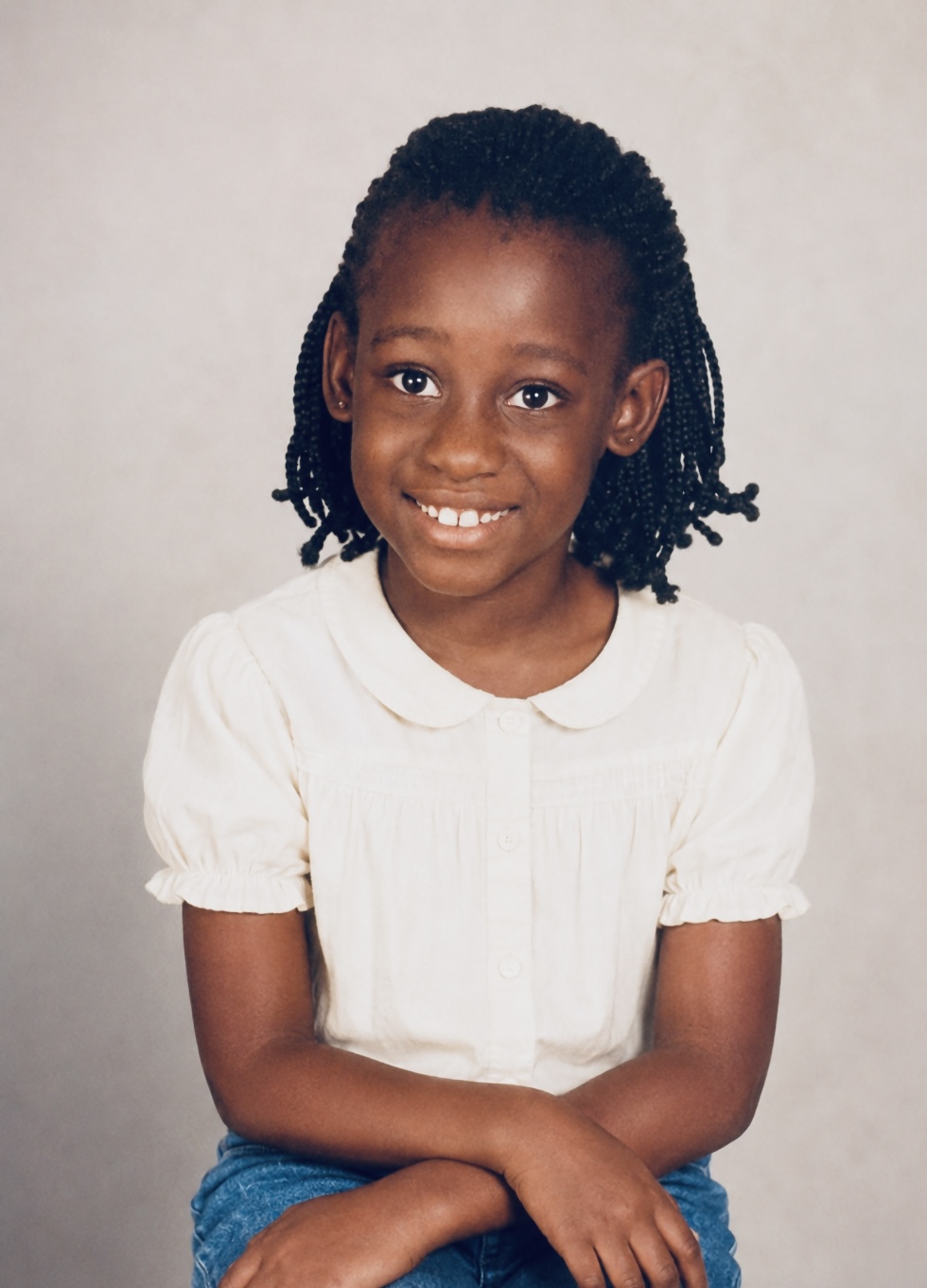 Childhood portrait of Shiloh seated and smiling