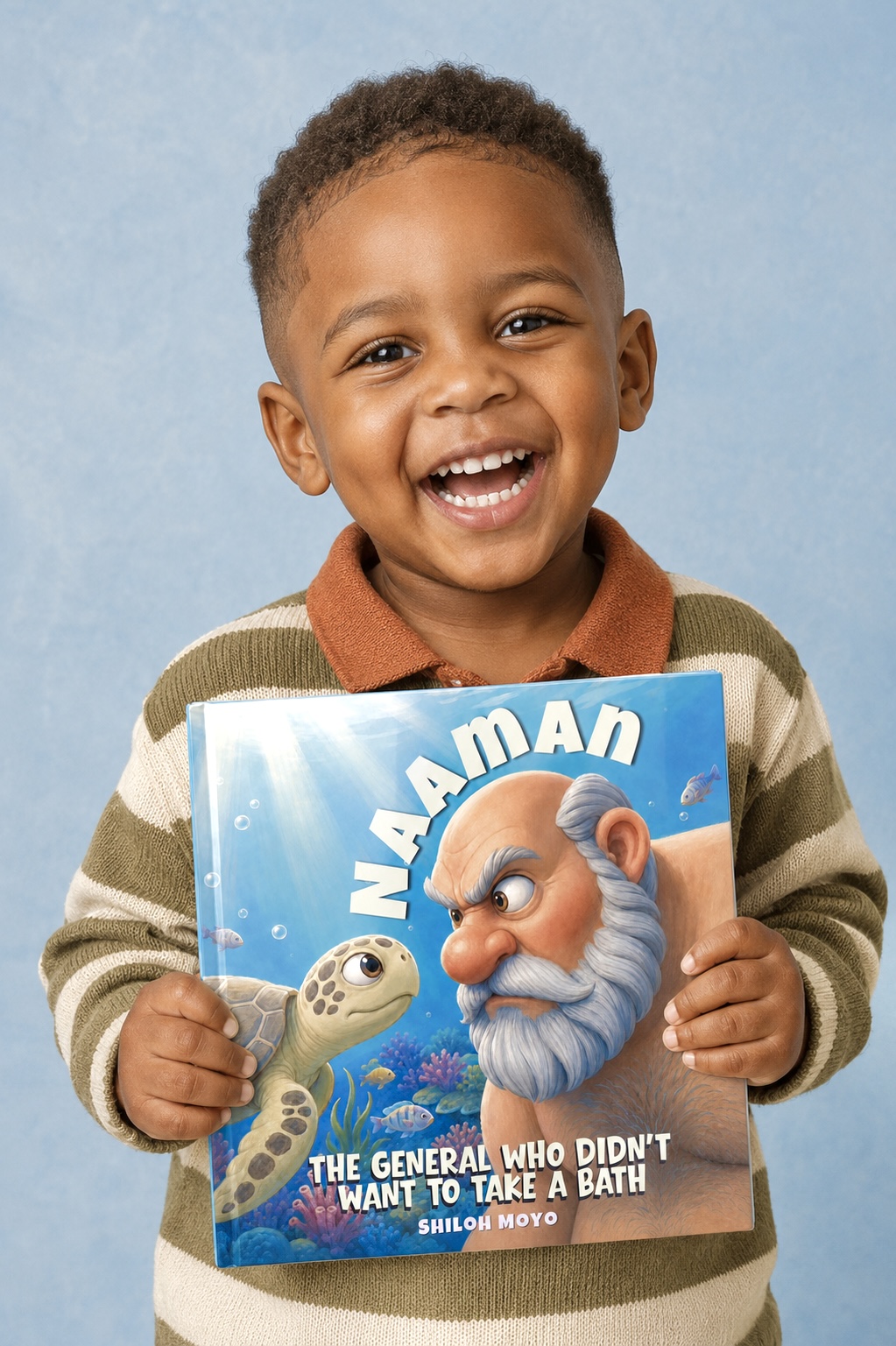 A smiling young boy holding Naaman